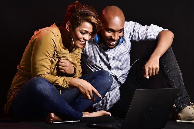 Man and woman laughing, laptop, setting goals