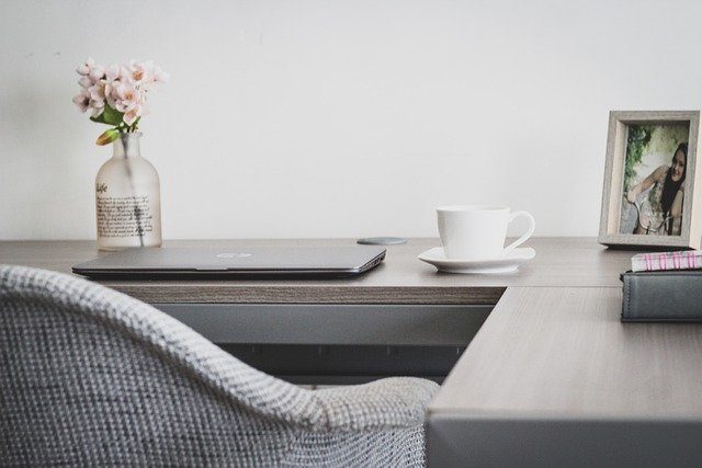 Office desk, coffee cup, chair, flowers