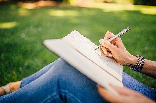 woman, outside, writing a book